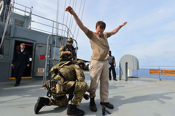 Royal Marines search a crew member during an exercise.